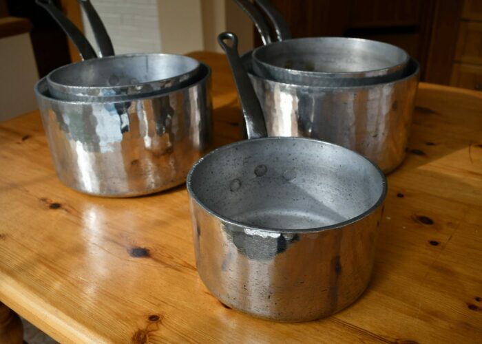 Set of five hammered aluminum saucepans